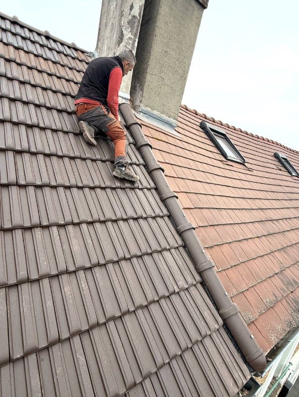 Pose de tuiles au faîtage près d'une cheminée par Bischoff Couverture dans l'Essonne